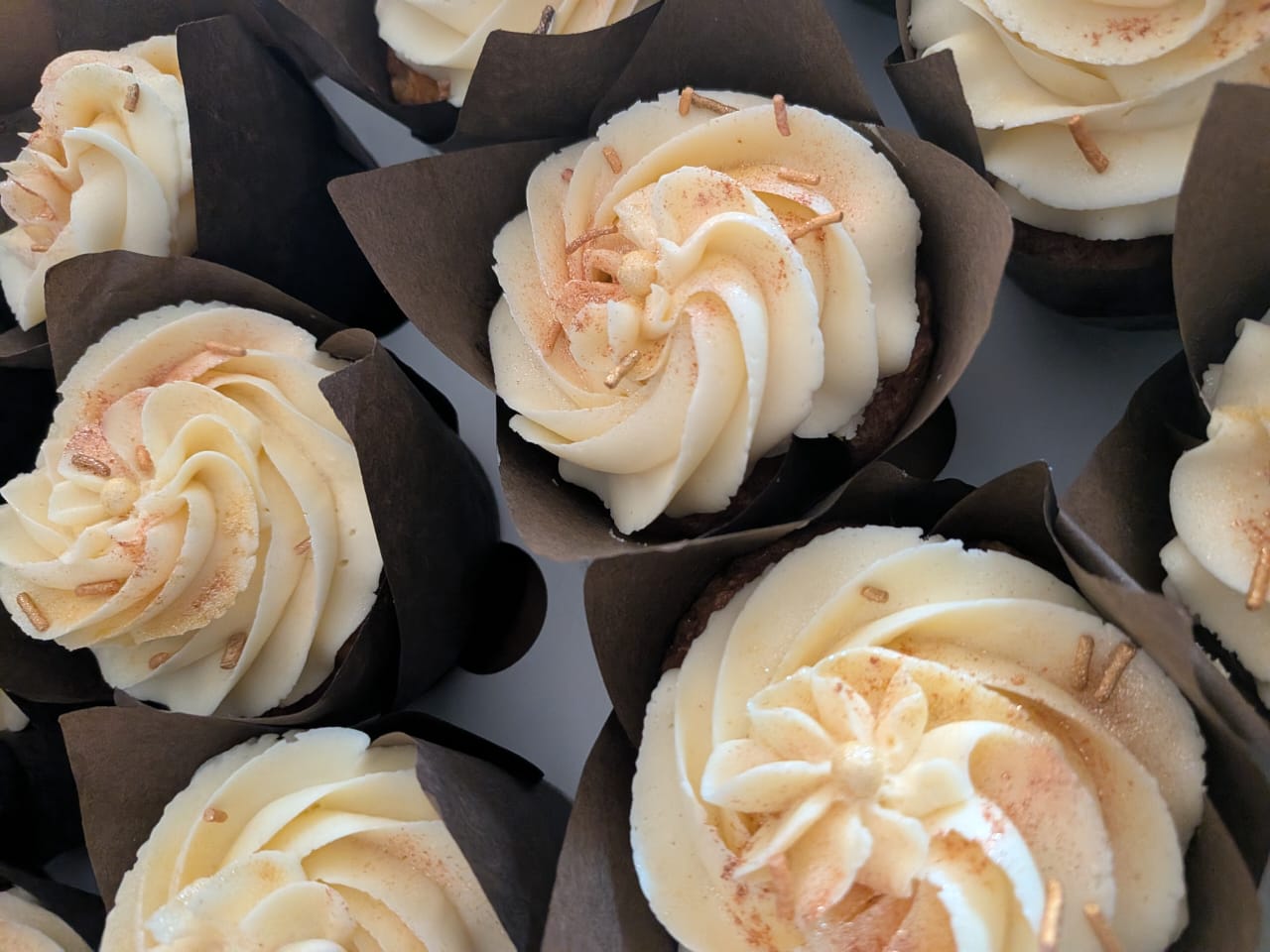 Vanilla cupcakes with buttercream rosettes, freshly baked by Homely Taste